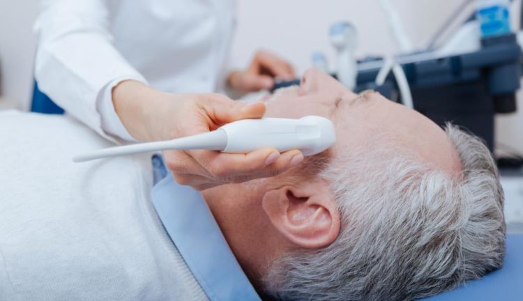 Caring-medical-specialist-providing-head-ultrasound-in-the-hospital-672482264_2125x1416