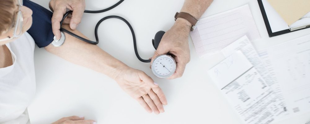 doctor-measuring-patients-blood-pressure-PQATB85