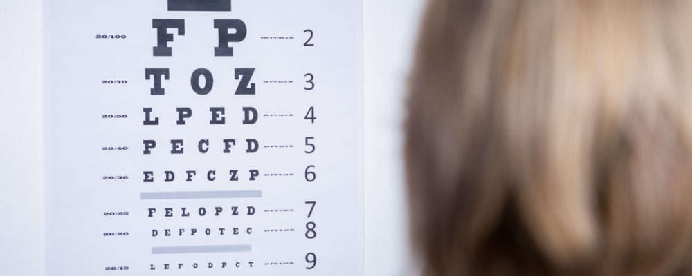optometrist looking at eye chart in ophthalmology clinic