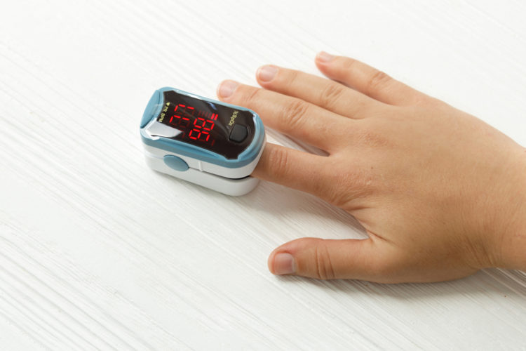 Pulse Oximeter on finger, measuring blood oxygen level, detecting coronavirus pneumonia