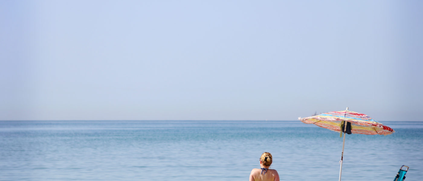 woman-sitting-at-the-beach-watching-the-sea-VDWSVQ3